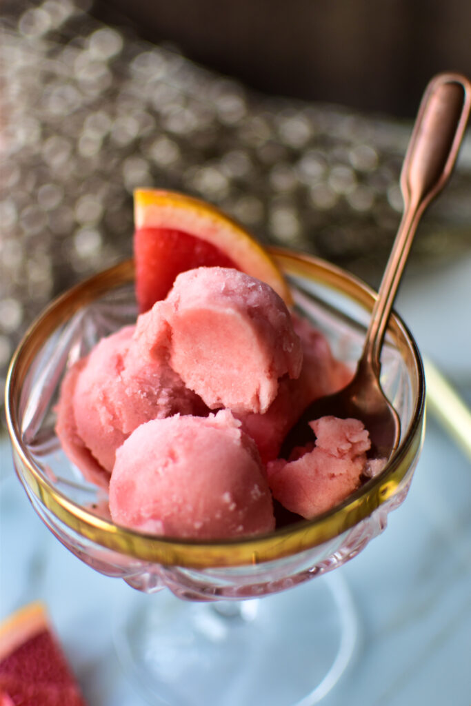 Grapefruit Sorbet in einem Champagnerglas serviert – elegantes Dessert für Silvester Detailbild mit Löffel.