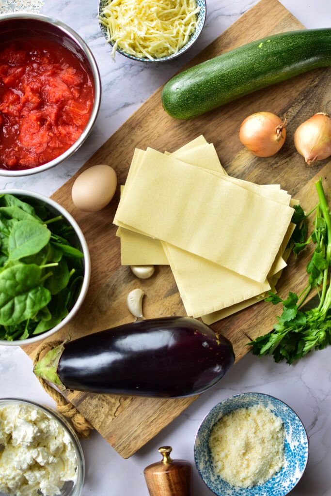 Zutaten für zarte Gemüselasagne im Slow Cooker, perfekt geschichtet mit saftigen Zucchini, Paprika und Aubergine.
