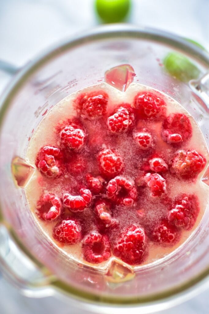 Himbeeren werden in einem Mixer zerkleinert für Himbeer Limonade