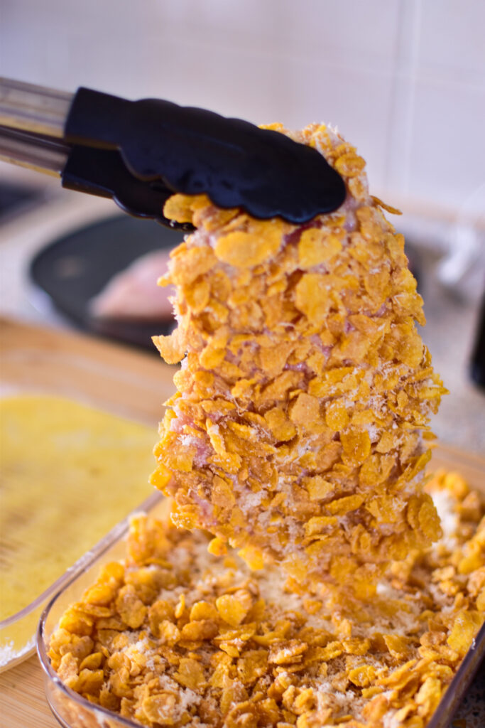 Eine Schnitzel mit Cornflakes Panade wird in der Heißluftfritteuse besonders knusprig