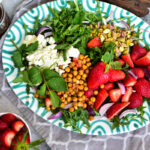 Entdecke ein erfrischendes Rezept für einen knusprigen Salat mit Erdbeeren, Kichererbsen und cremigem Feta - ideal für die warmen Tage!