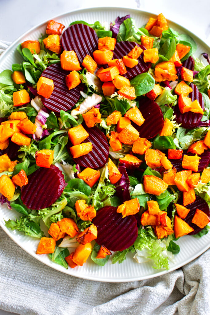 Herbstlicher Ernte-Salat mit Kürbis, Roter Bete und gerösteten Kürbiskernen, serviert mit Balsamico-Dressing