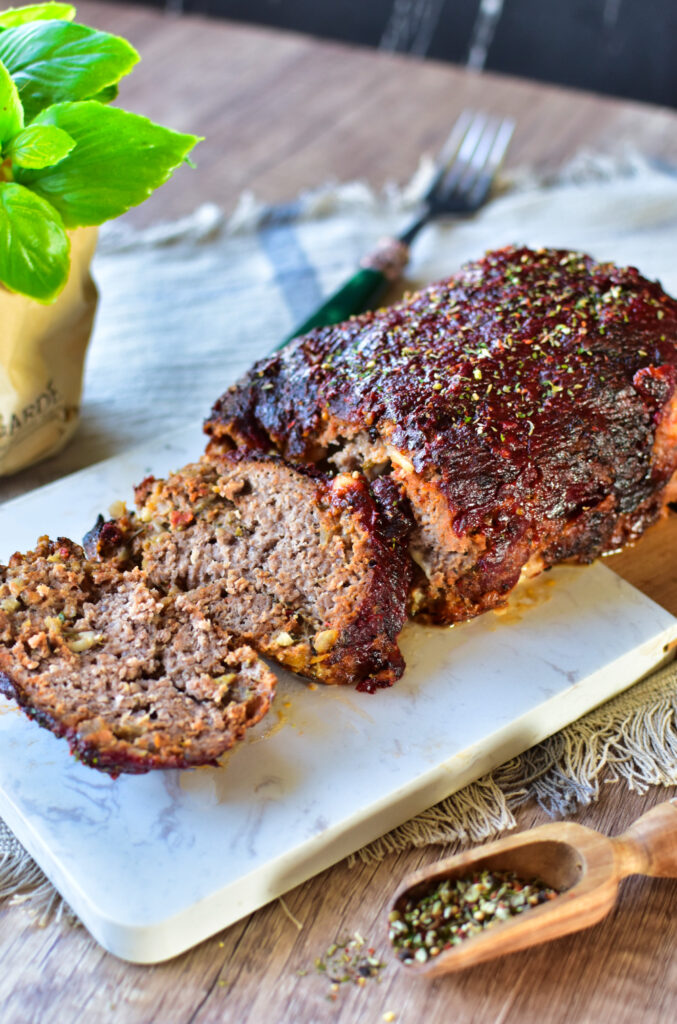 Saftiger Hackbraten aus dem Airfryer mit knuspriger Glasur, angerichtet auf einem Brettchen.