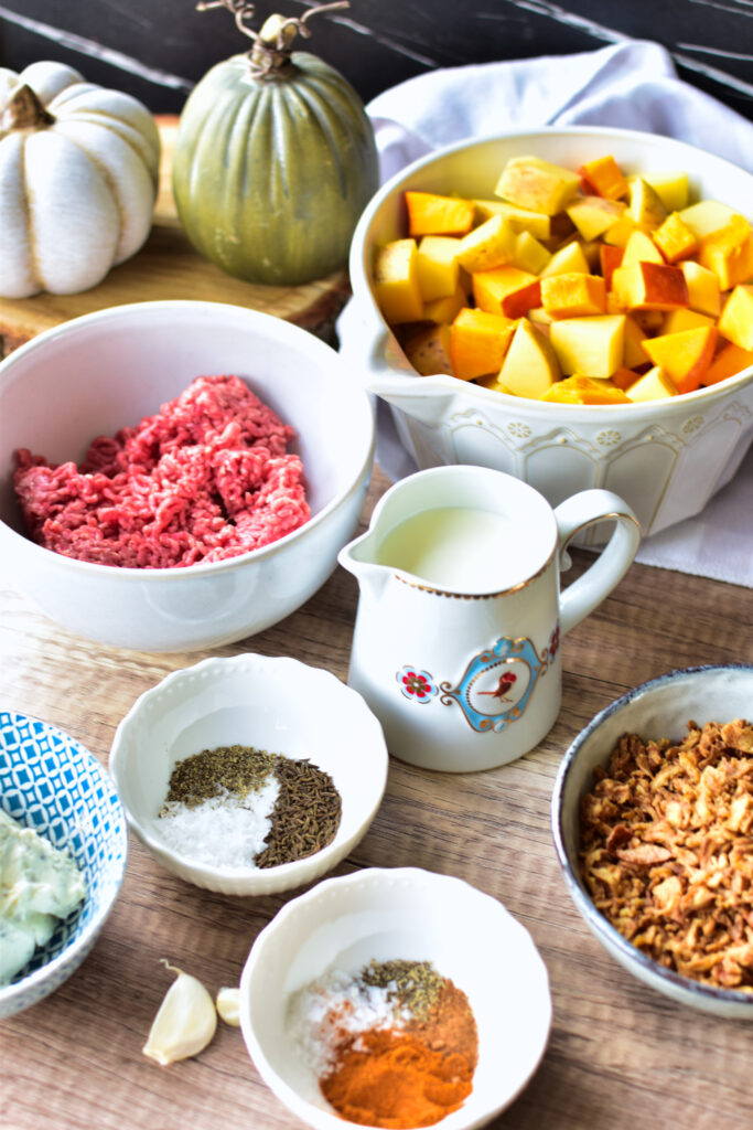 Alle zutaten auf einen Blick: Hackfleisch, Kartoffeln, Kürbis in Würfeln, Sahne, Frischkäse, Knoblauch und Gewürze.