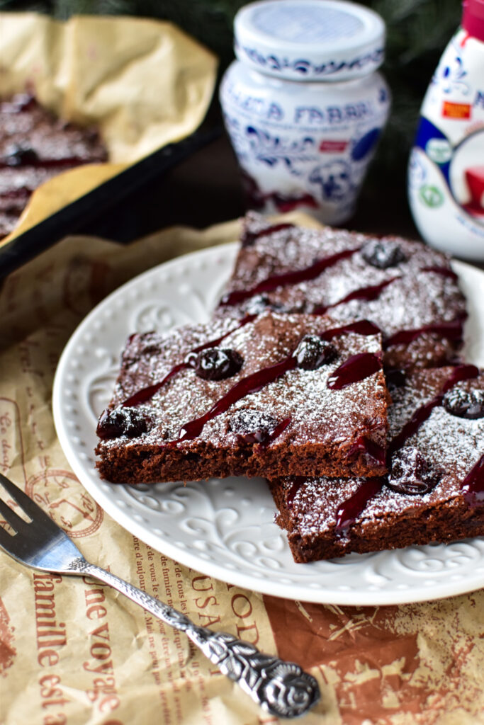 Weihnachtskuchen-Blechkuchen mit Amarena-Kirschen und Lebkuchengewürz aufgeschnitten serviert