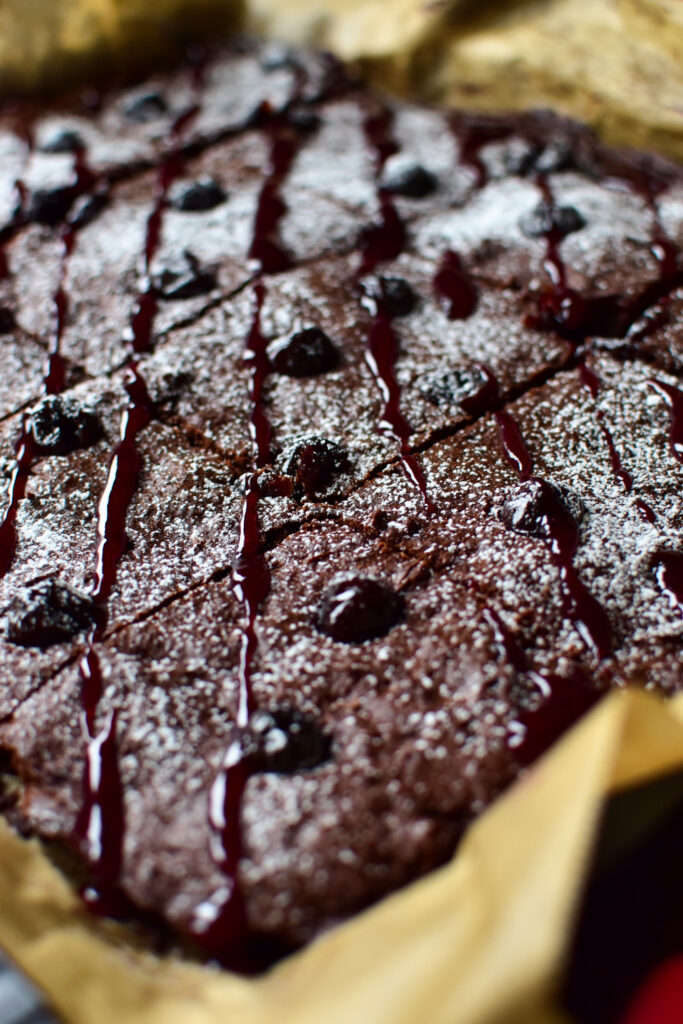 Nahaufnahme von saftigem Weihnachtskuchen-Blechkuchen mit Schokolade und Amarena-Kirschen