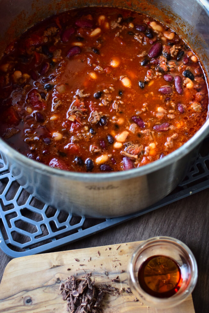 Dampfendes Chili con Carne mit Bohnen und Tomaten in einem großen Topf – ideal für stressfreie Partys.