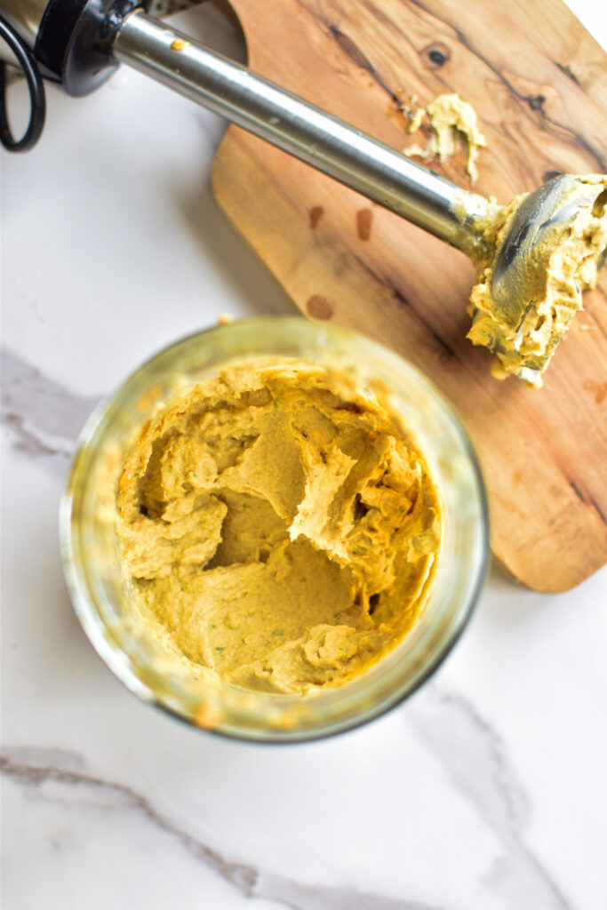 Einfache Zubereitung von Hummus: cremige Masse in einem Mixer mit Kichererbsen und Zitrone.“