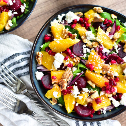 Frischer Rote Bete Salat mit Orangen, Feta und Granatapfelkernen auf einem Teller angerichtet.