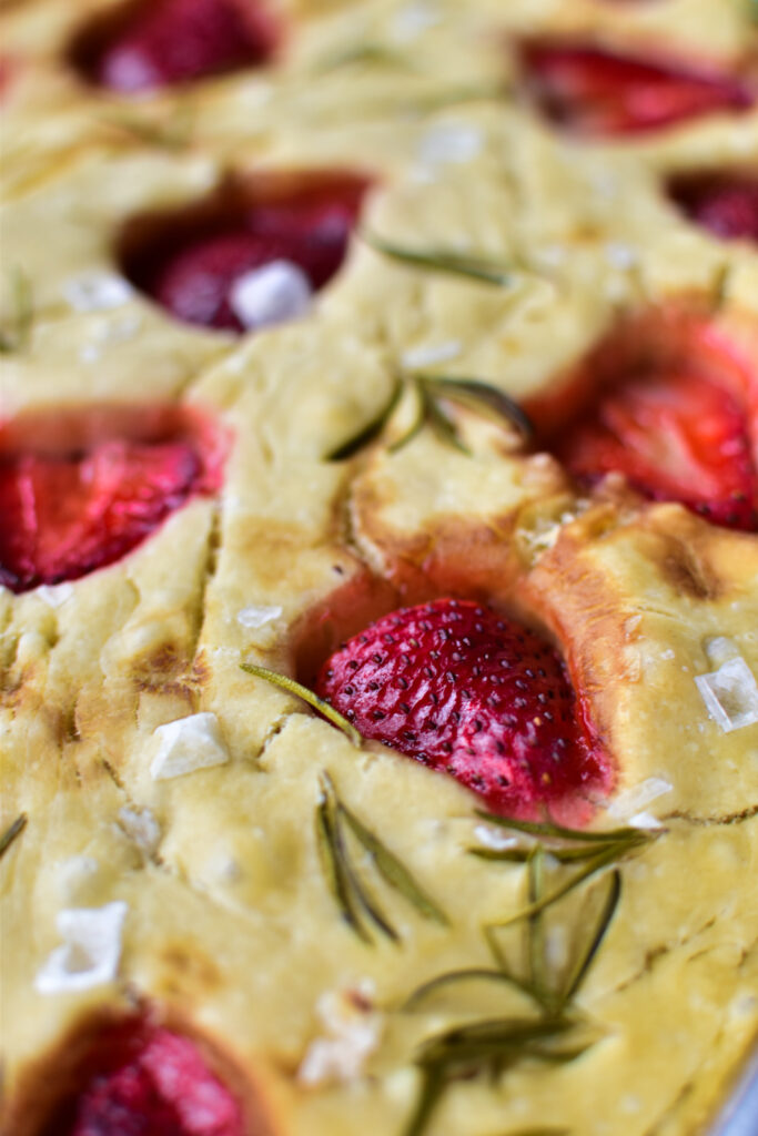 Nahaufnahme einer Erdbeer Focaccia mit frischem Rosmarin und karamellisierten Erdbeeren