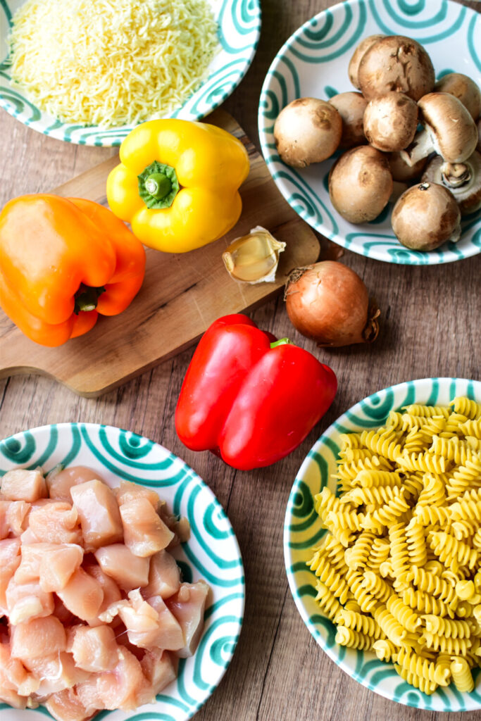 Zutaten für dieses Partyrezept aus dem Backofen mit Hähnchen, Paprika, Nudeln und Champignons.