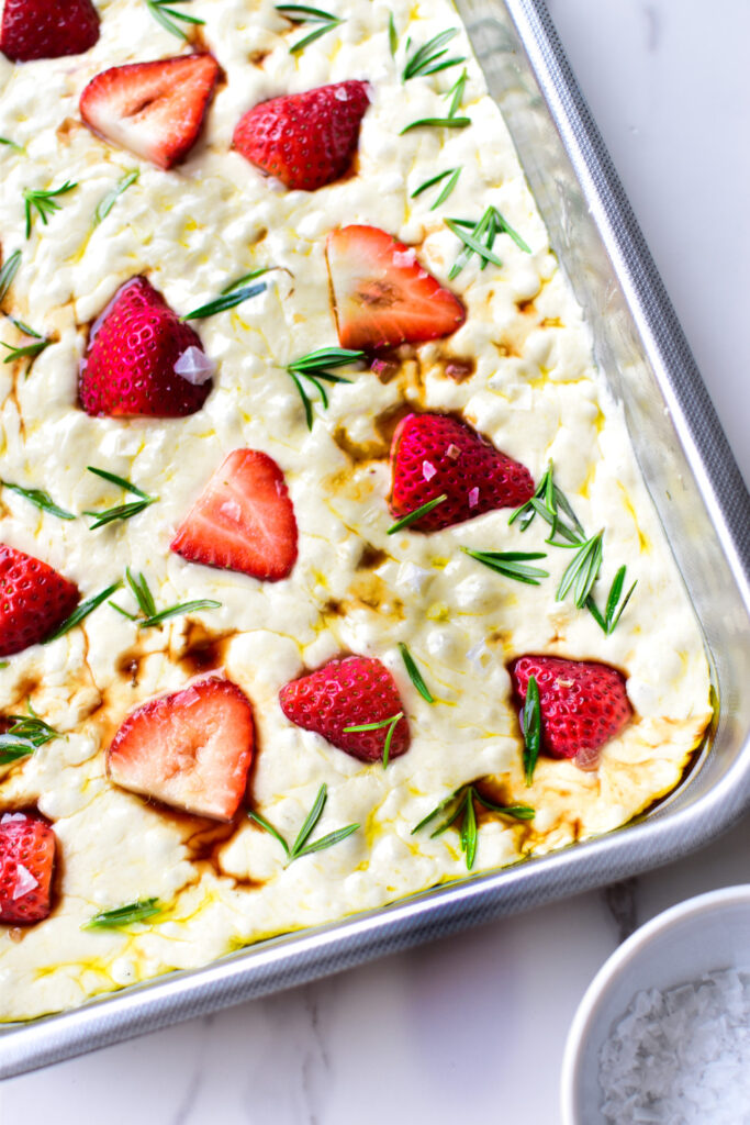 Frische Erdbeeren gleichmäßig auf dem Focaccia-Teig verteilt