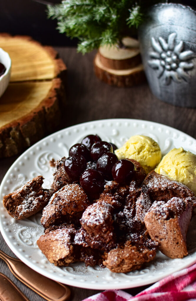 Angerichteter Airfryer Schokoschmarrn mit Kirschen und zwei kugeln Vanilleeis.