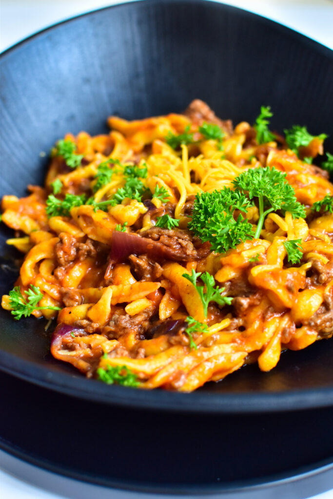 Eine Portion schnelle Cheeseburger Spätzle auf einem Teller, garniert mit Petersilie
