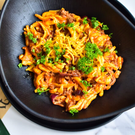 Frisch zubereitete Cheeseburger Spätzle in der Pfanne mit geschmolzenem Cheddar