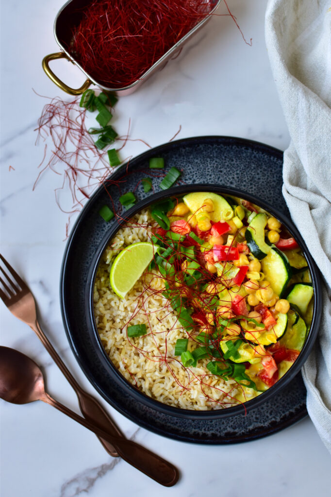 Cremiges Curry mit Kichererbsen, Paprika und Zucchini aus dem Airfryer in einer Schüssel serviert