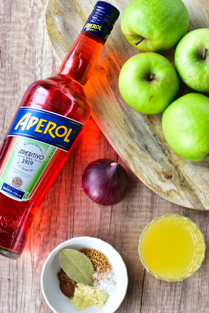 Zutaten für Apfel-Aperol-Chutney auf Holzbrett angerichtet