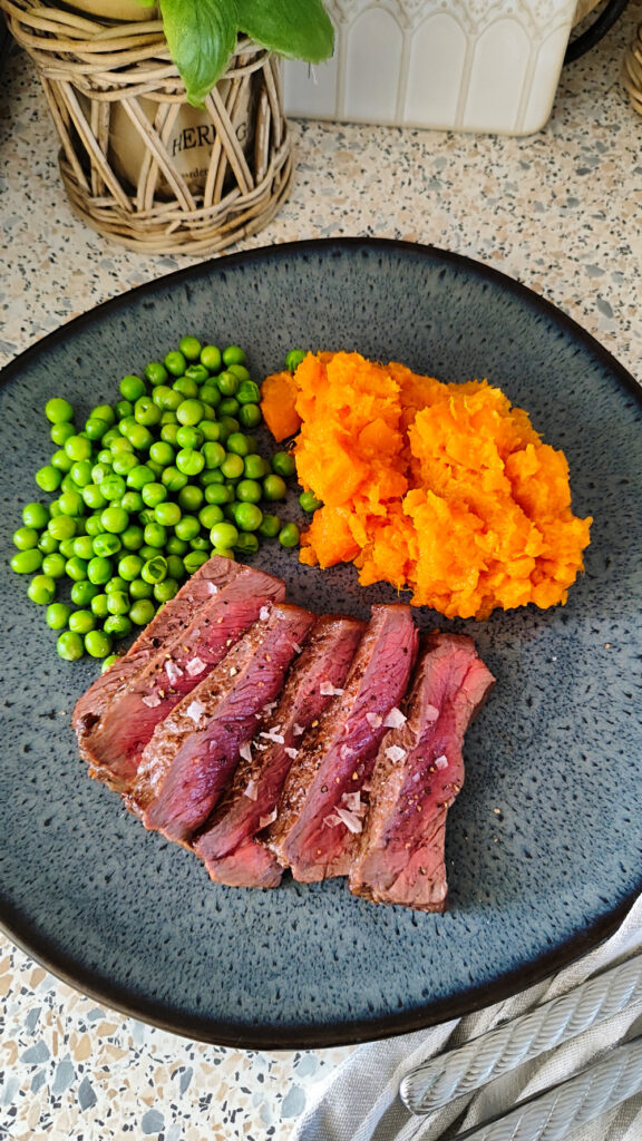 Perfektes Steak im Airfryer zubereitet, angerichtet mit Beilagen und grobem Meersalz.