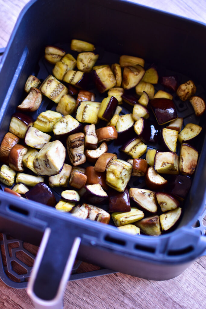 Marinierte Auberginenstücke im Airfryer-Korb.