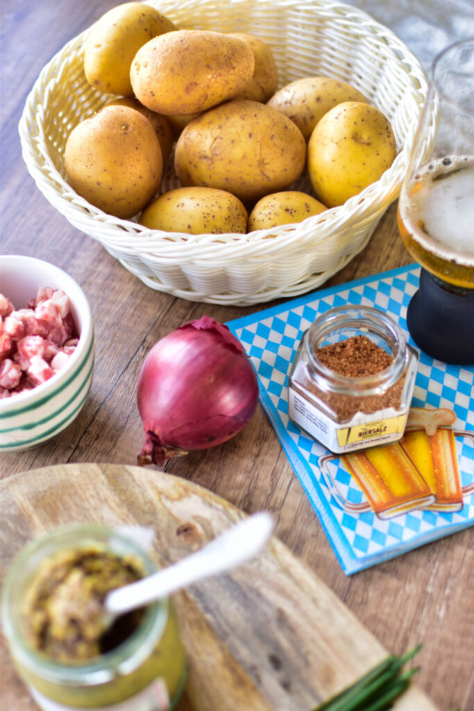 Herzhafter Kartoffelsalat mit Bier, Speckwürfeln und Röstzwiebeln.