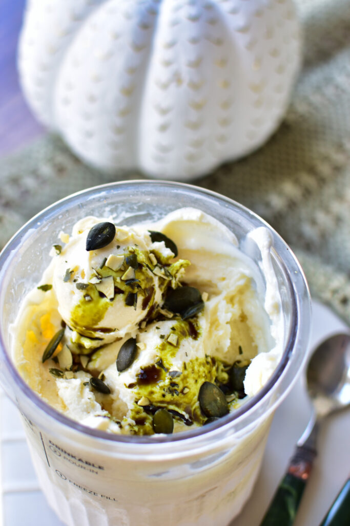 Detail Kürbiskern-Eiscreme mit Kürbiskernöl und knackigen gerösteten Kernen als Topping.
