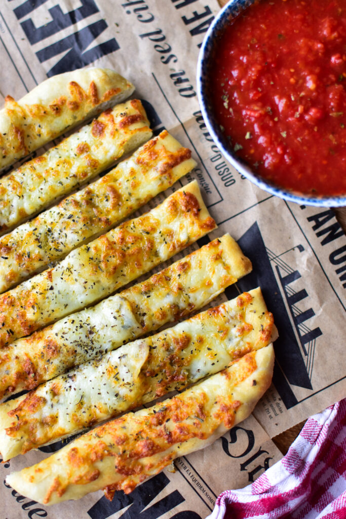 Airfryer Pizzastangen auf Backpapier, goldbraun und mit geschmolzenem Käse überzogen