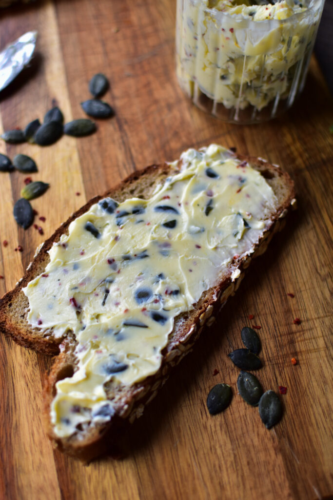 Die selbstgemachte Kräuterbutter auf ein Brot geschmiert.