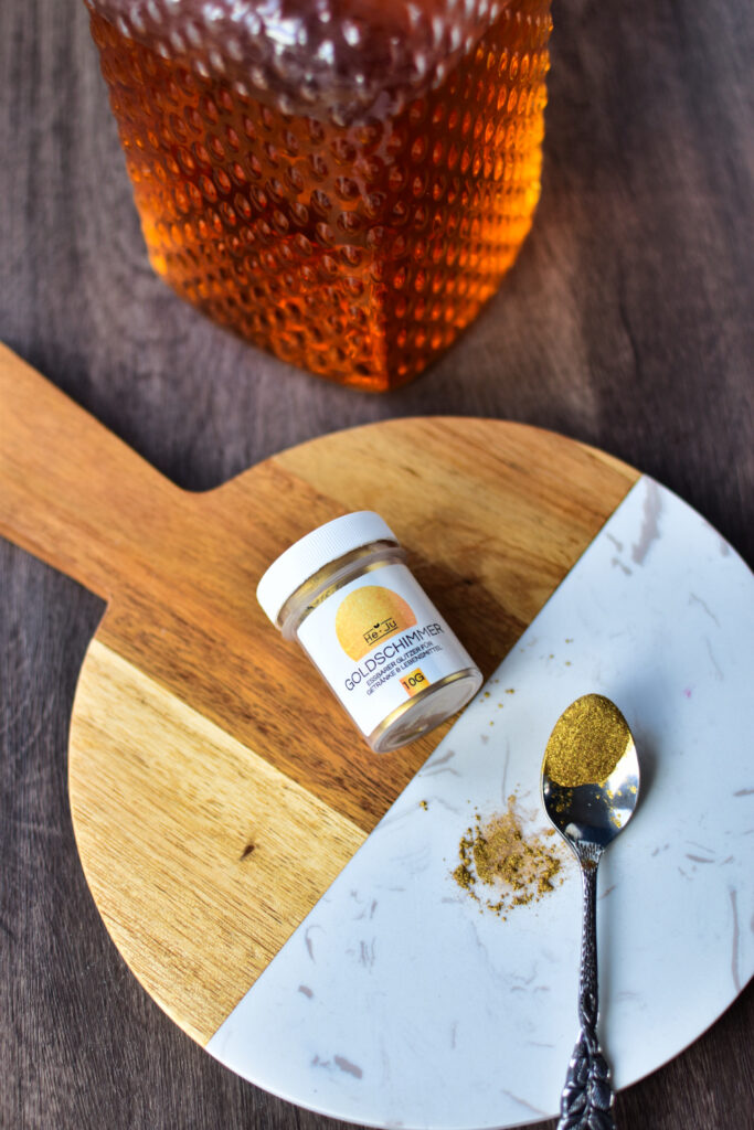 Glitzerpulver für das Goldene Punsch Rezept auf einem Brettchen.