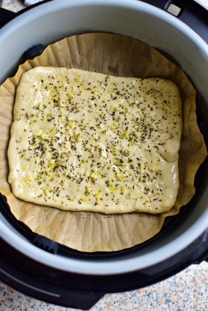 Pizza Snack Airfryer im Korb, mit Olivenöl bepinselt und mit Kräutern bestreut