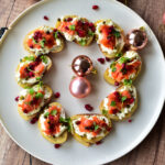 Lachs-Crostini als Weihnachtsvorspeise auf weißer Servierplatte angerichtet