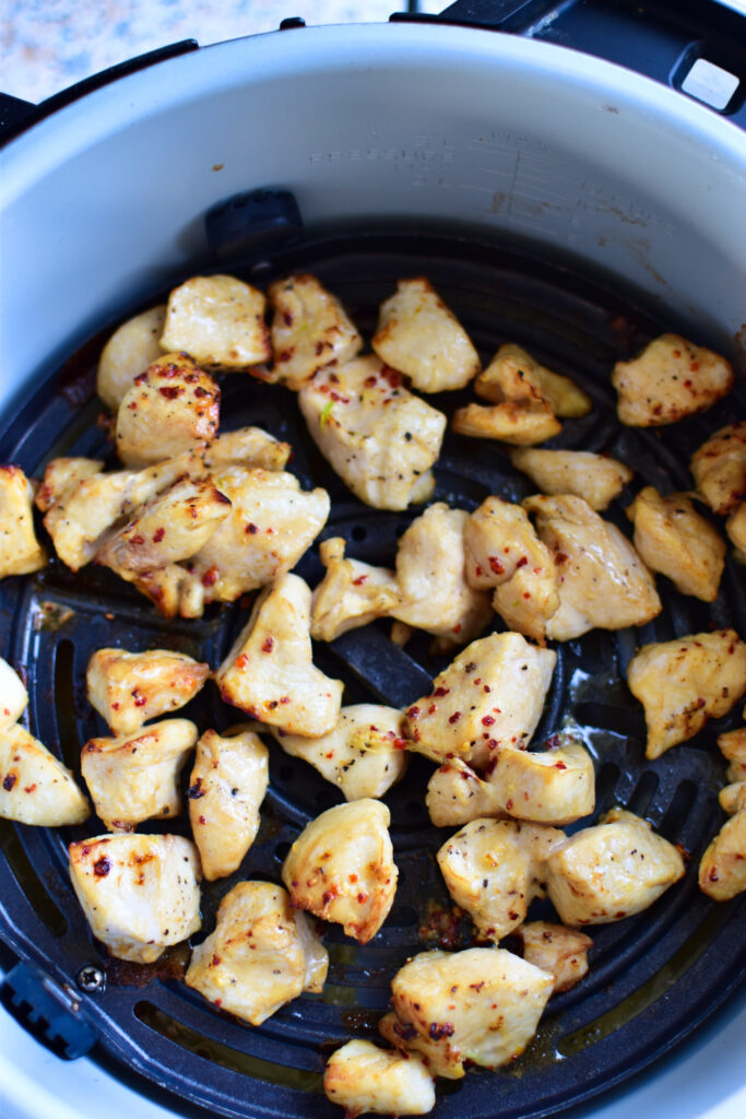 Hähnchen-Stückchen mit Hot Honey Glasur im Korb der Heissluftfritteuse.