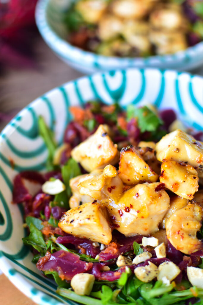 Knackiger Wintersalat mit Rotkohl, Rucola und asiatischem Dressing Detail Bild des angerichteten Salats.