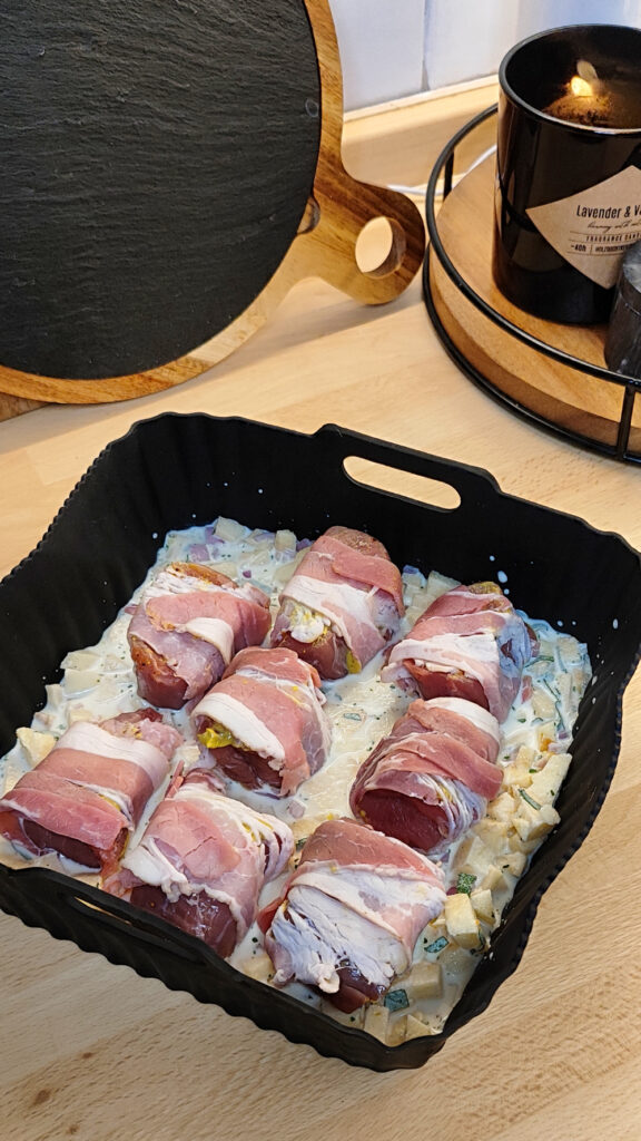 Schweinefilet im Speckmantel mit Sauce in einer Auflaufform, bereit für die Heißluftfritteuse.