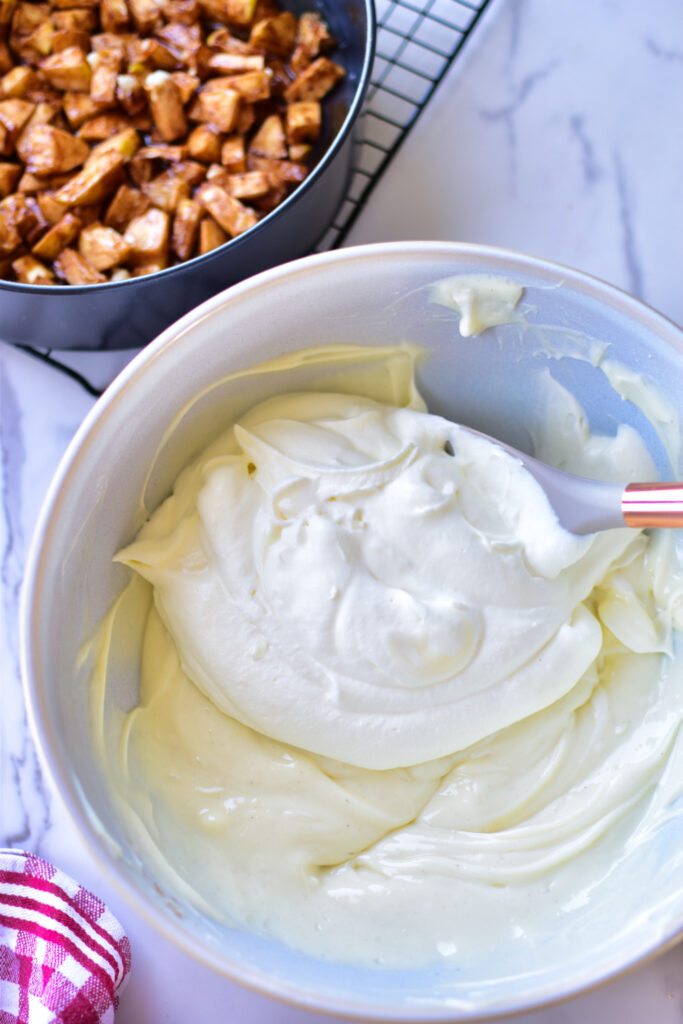 Frischkäsemasse wird mit Sahne verrührt.