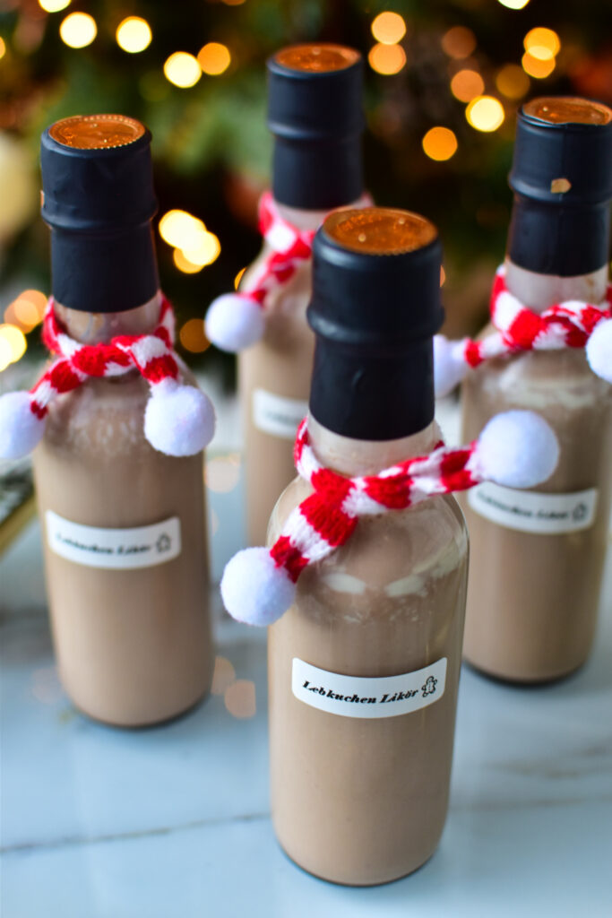 Selbstgemachter Lebkuchen Likör als Geschenkidee – liebevoll abgefüllt in kleine Glasflaschen mit rotem Schal.