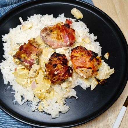 Aim Ninja Airfryer gebackenes Schweinefilet im Speckmantel auf einem Teller serviert.