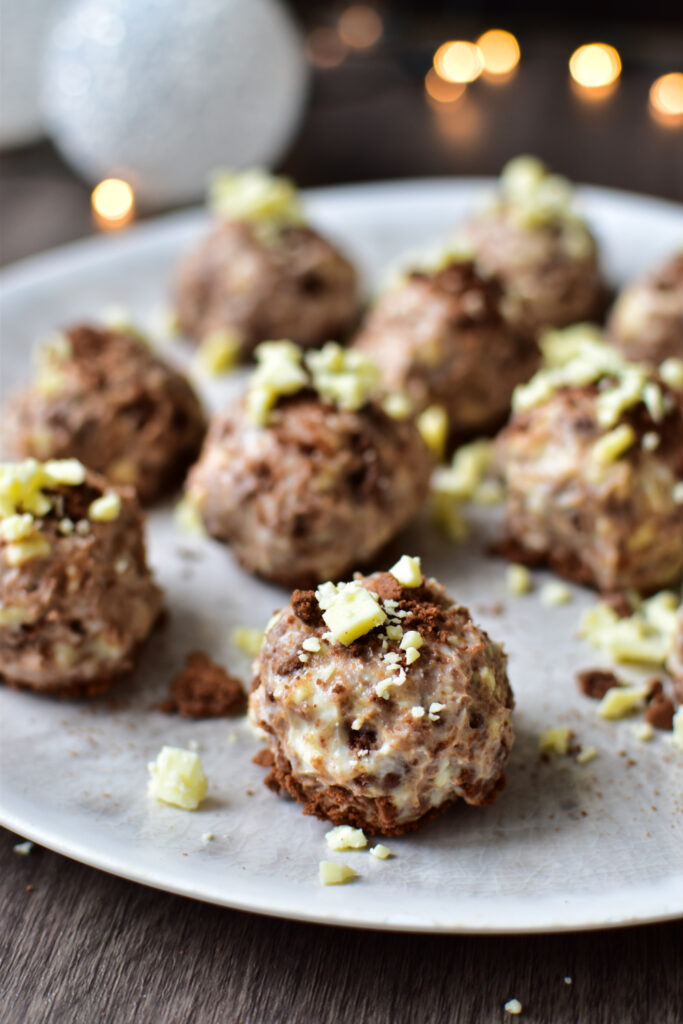Nahaufnahme von weihnachtlichen Cheesecake-Kugeln mit Spekulatius und Schokoladenraspeln – festliche Leckerei für den Advent.