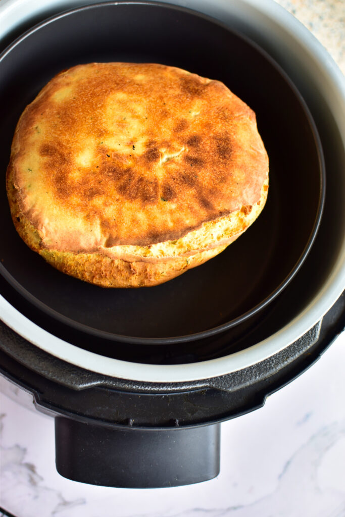 Goldbraunes Airfryer-Brot ohne Hefe mit goldbrauner Kruste im Korb der Heißluftfritteuse