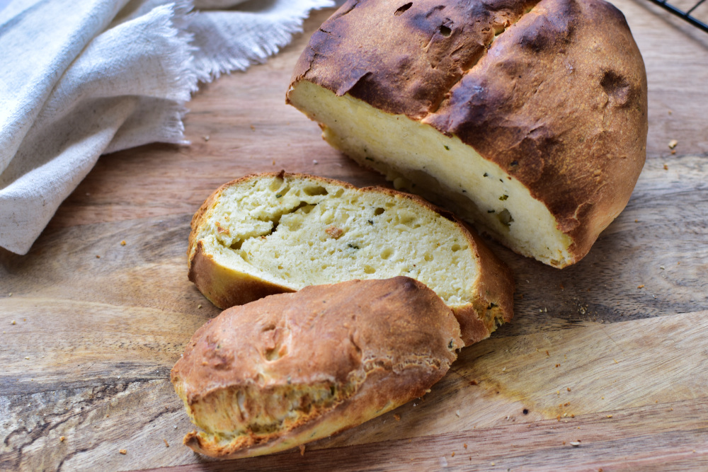 Einfaches Brot backen im Airfryer – saftiges Quarkbrot ohne Hefe angeschnitten auf einem Brett.
