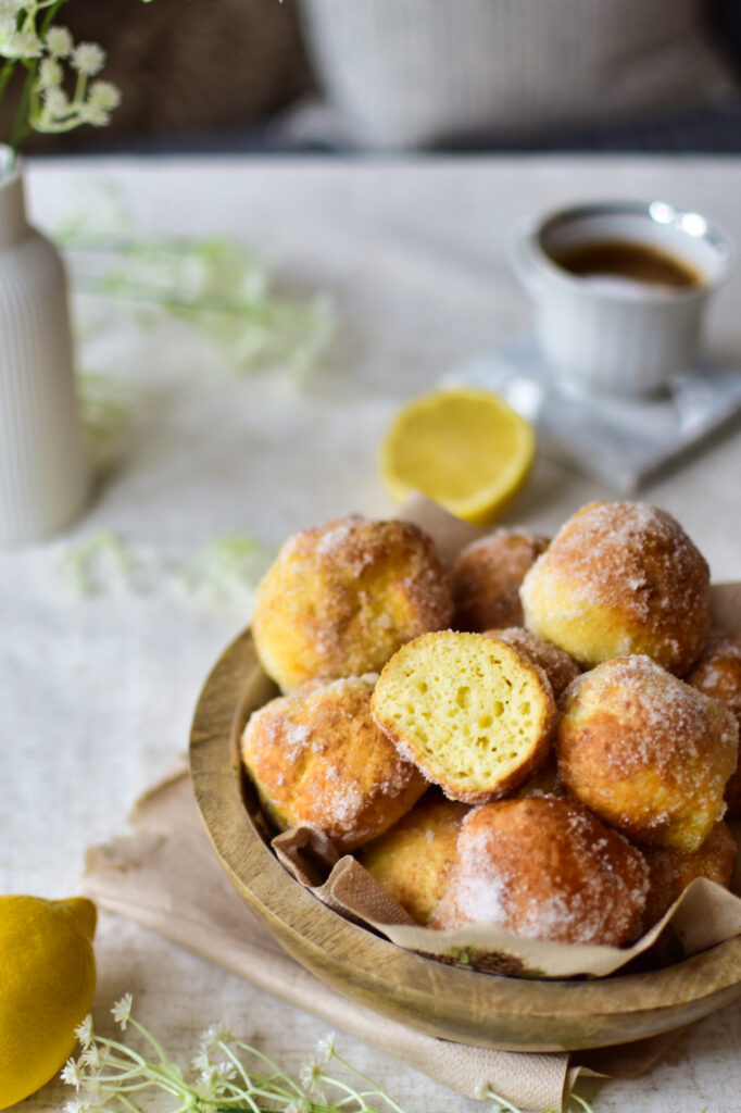 Aufgeschnittene luftige Quarkbällchen aus dem Airfryer auf einem Tisch zum Kaffee serviert.