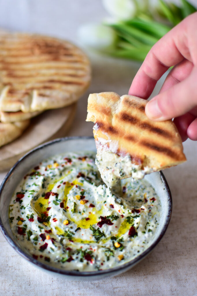 Frischer Bärlauch Dip als Brotaufstrich serviert in einer blauen Schale.
