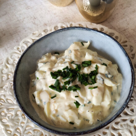 Eiersalat in einem blauen Schälchen serviert.