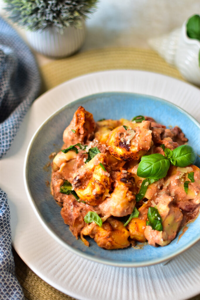 Servierte cremige Tortellini mit Parmesan und Basilikum aus dem Airfryer