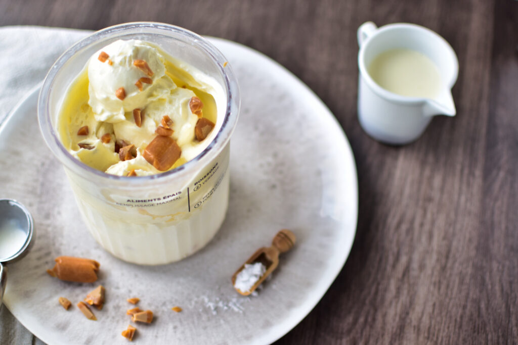 Einfaches Eis im Ninja Creami Deluxe Becher mit Karamellstückchen und Meersalz serviert.