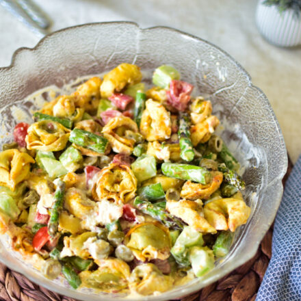Lauwarmer Tortellinisalat mit knusprig panierten Tortellini aus dem Airfryer und grünem Spargel in einer stylischen Schüssel, fertig serviert für die Grillparty.