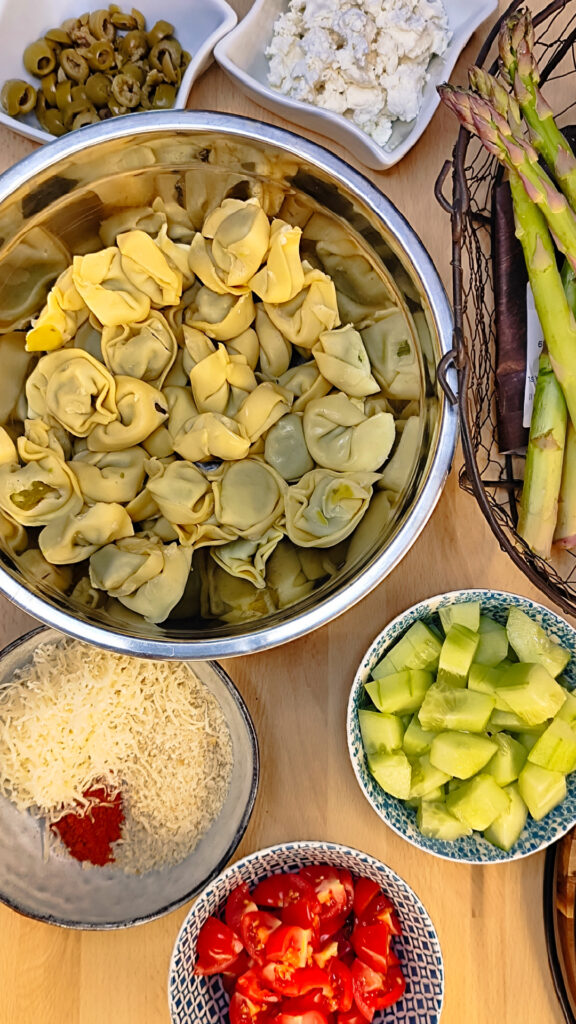 Frische Tortellini werden in einer Schüssel mit Olivenöl, Parmesan und Semmelbröseln für die Zubereitung in der Heißluftfritteuse vermengt.