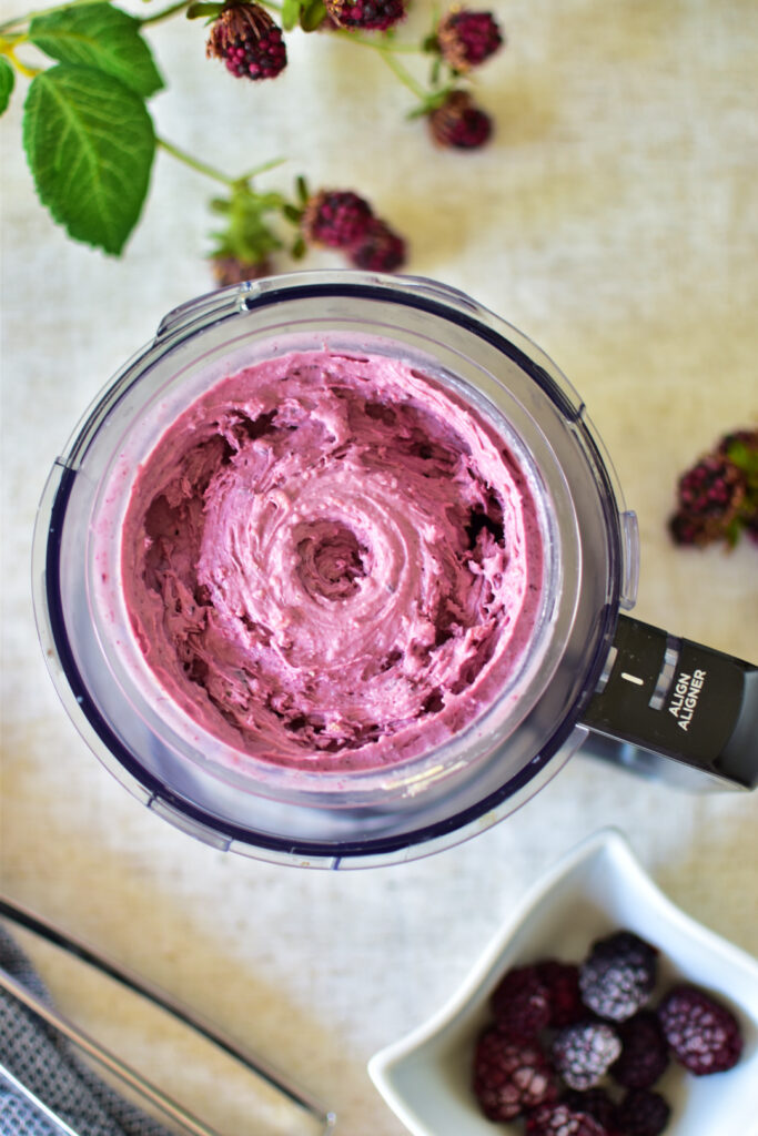 Eine Portion violettes Beeren-Gelato im Ninja Creami Deluxe Becher vor dem Mix-In.