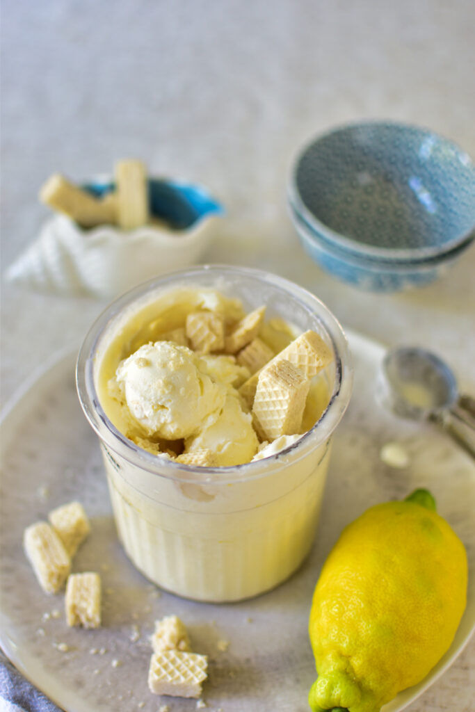 Cremiger Ninja Creami Frozen Joghurt Zitrone dekoriert mit knusprigen Zitronenwaffeln.