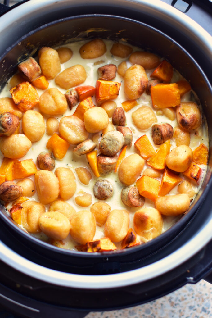Goldbraun überbackener Gnocchi-Auflauf mit Kürbis und Sahne Sauce frisch aus der Heißluftfritteuse.