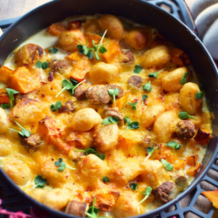 Cremiger Airfryer Gnocchi Auflauf mit Kürbis, Bratwurst und goldbrauner Käsekruste in einer Auflaufform.